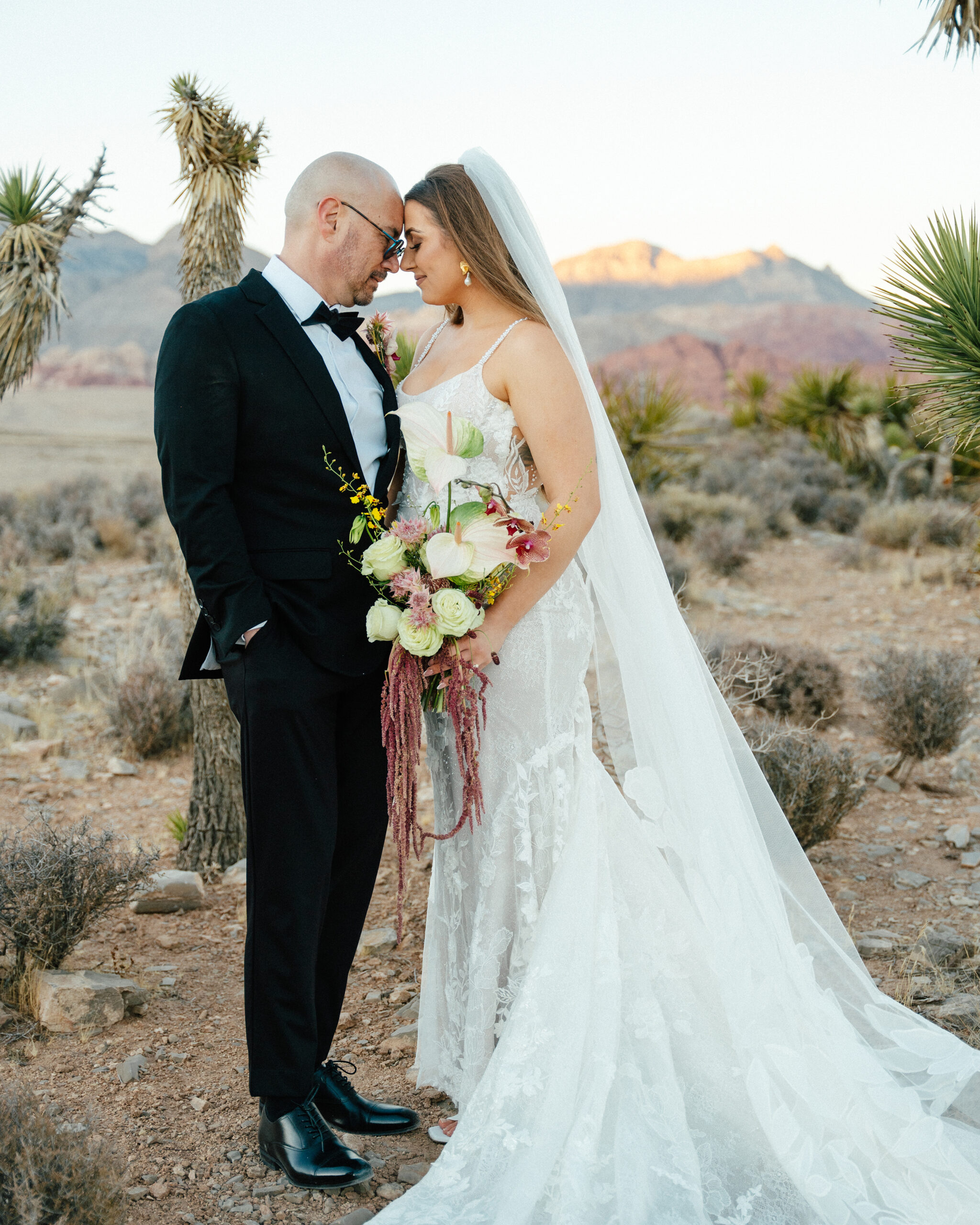 newlyweds share an intimate moment at sunset just after their red rock canyon overlook wedding