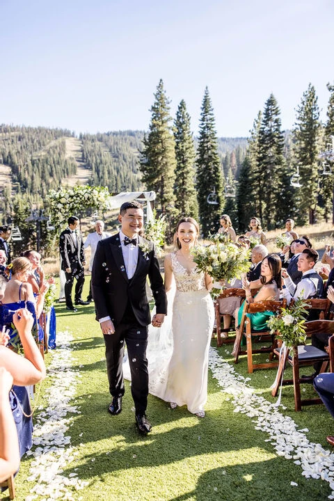 a couple celebrates as they walk down the aisle during their wedding ceremony at the ritz carlton in lake tahoe
