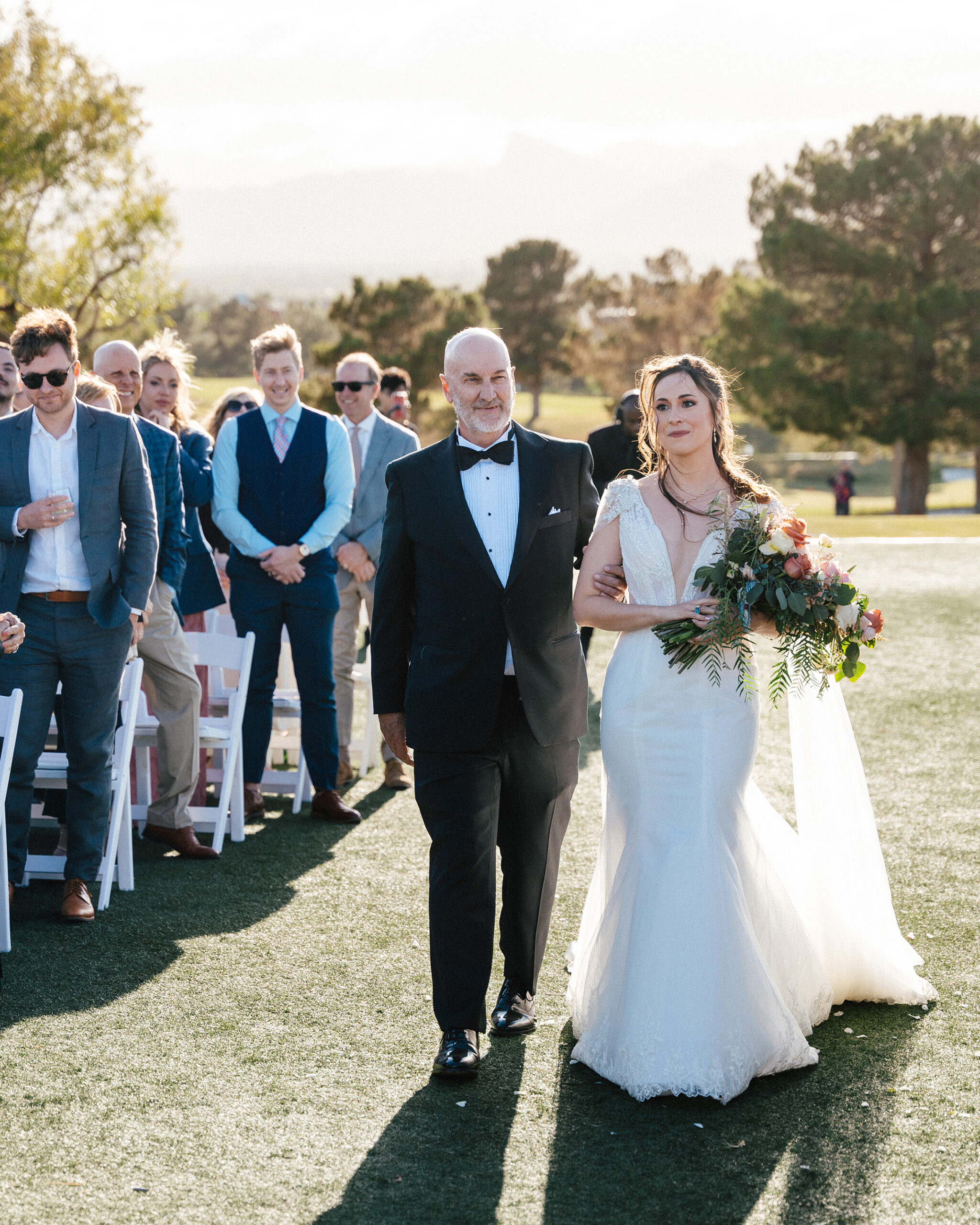 Bride walking arm-in-arm with her father down the aisle at an outdoor wedding ceremony at TPC Summerlin in Las Vegas