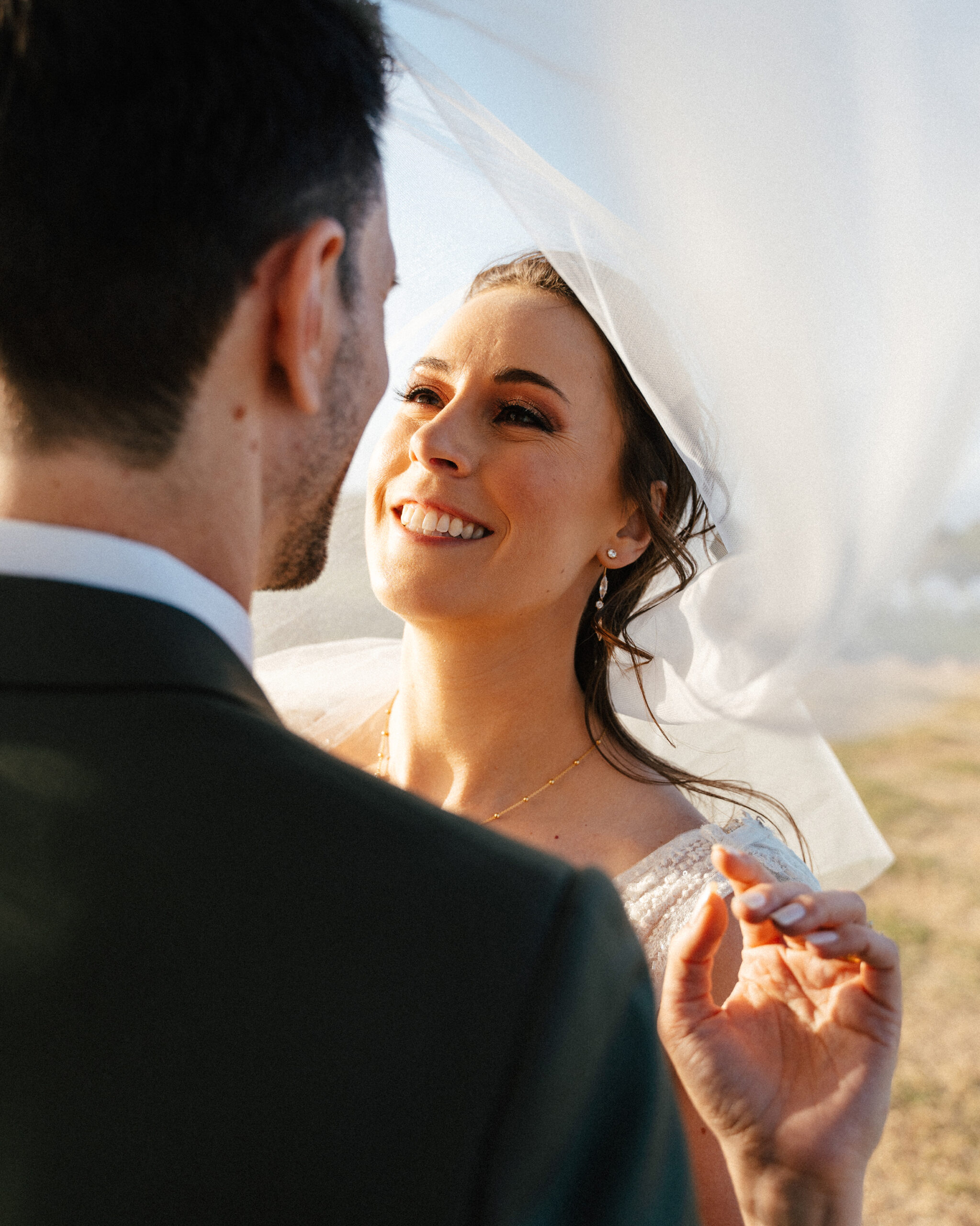 Bride smiling lovingly at the groom under her veil during a quiet moment at their TPC Summerlin wedding in Las Vegas