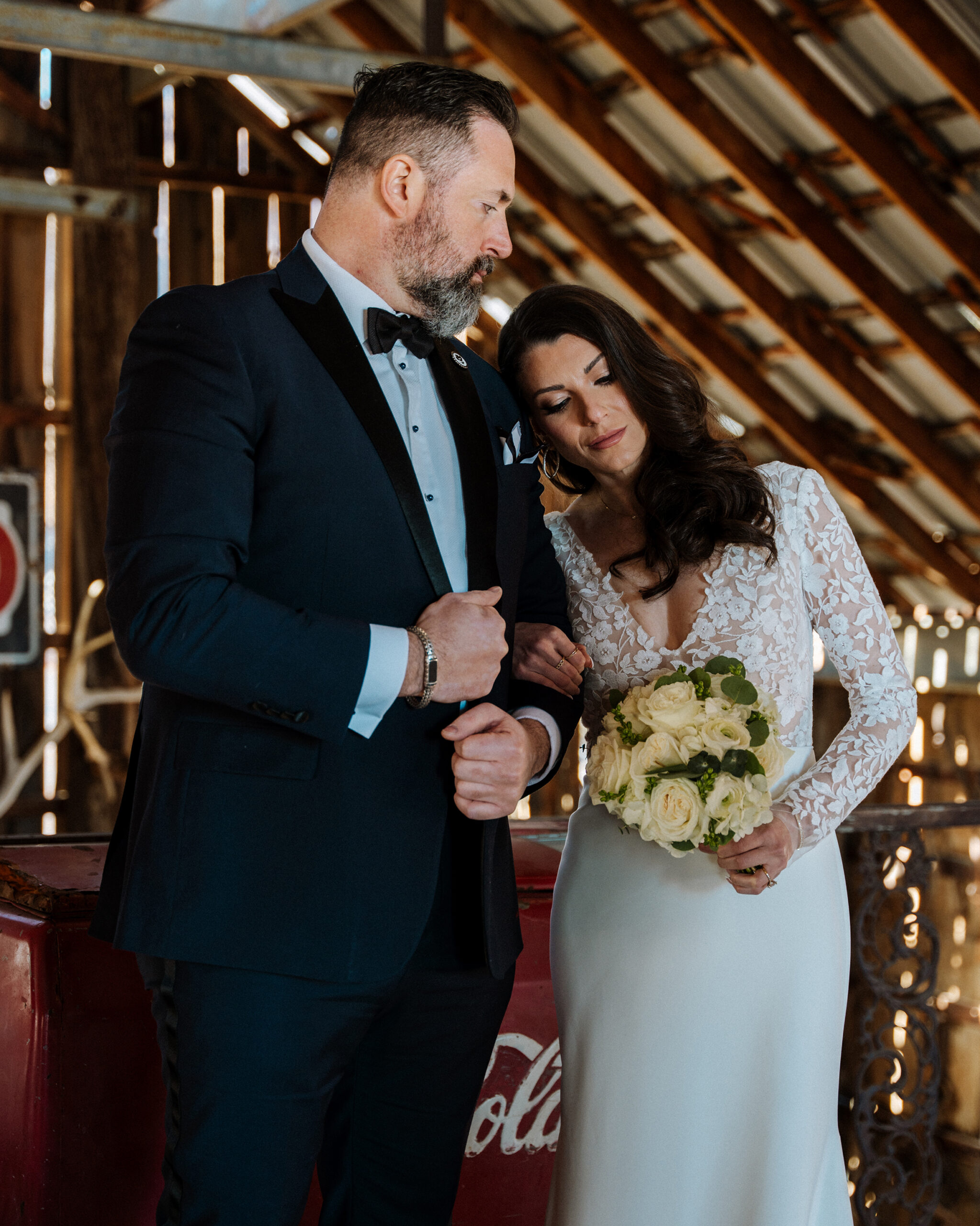 Groom comforting bride holding bouquet during a quiet moment inside Nelson Ghost Town barn