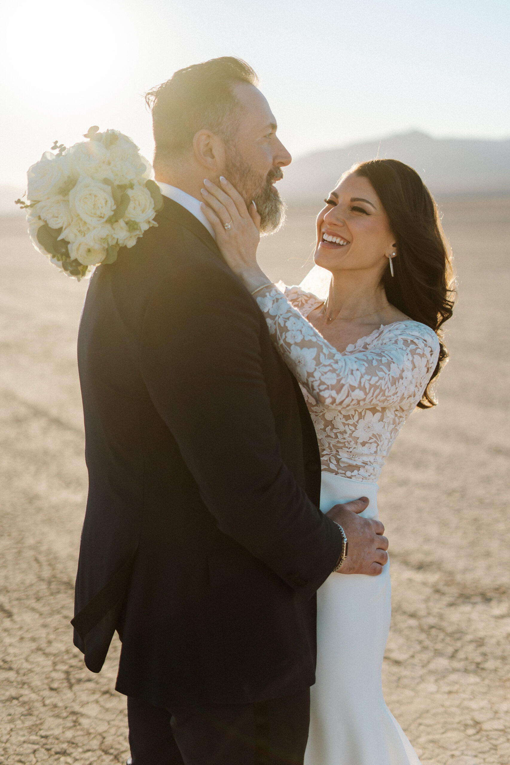 Bride smiling at groom during golden hour desert portraits after Nelson Ghost Town wedding