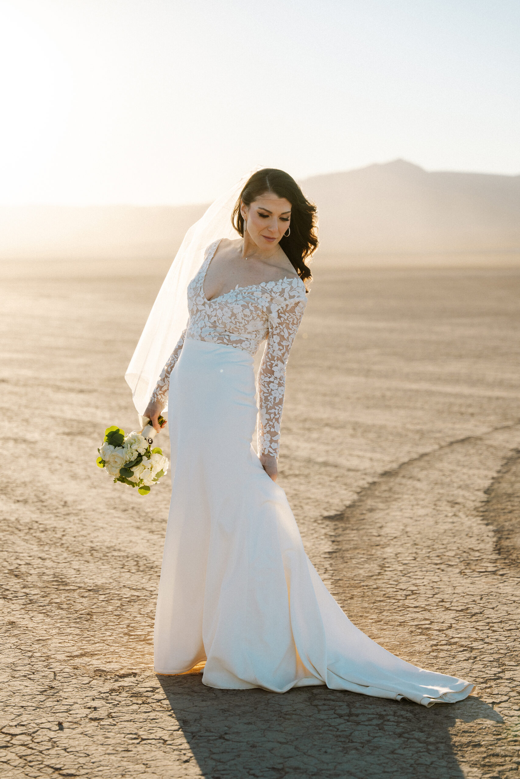 Bride holding bouquet and smiling in the desert during Nelson Ghost Town wedding