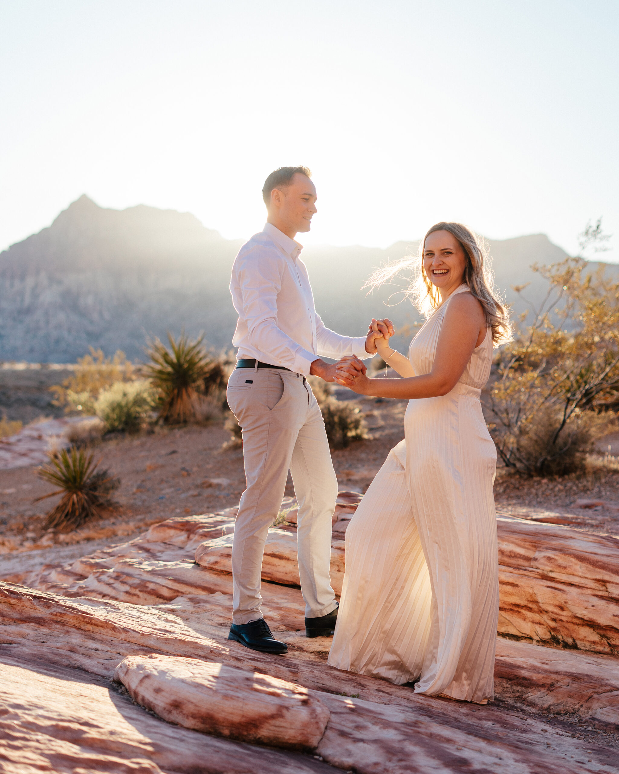couple dances in the golden glowing light at sunset in red rock canyon just outside of Las Vegas, NV