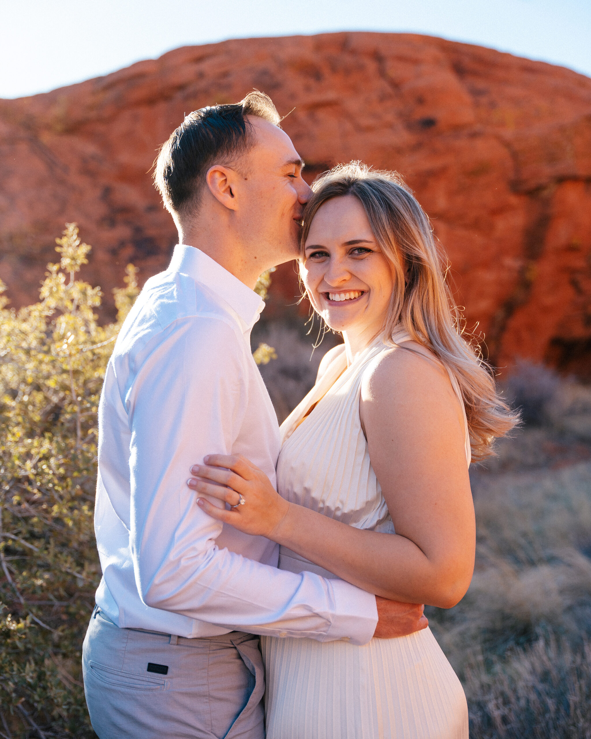 groom kisses bride on the forehead during golden hour in red rock canyon, NV