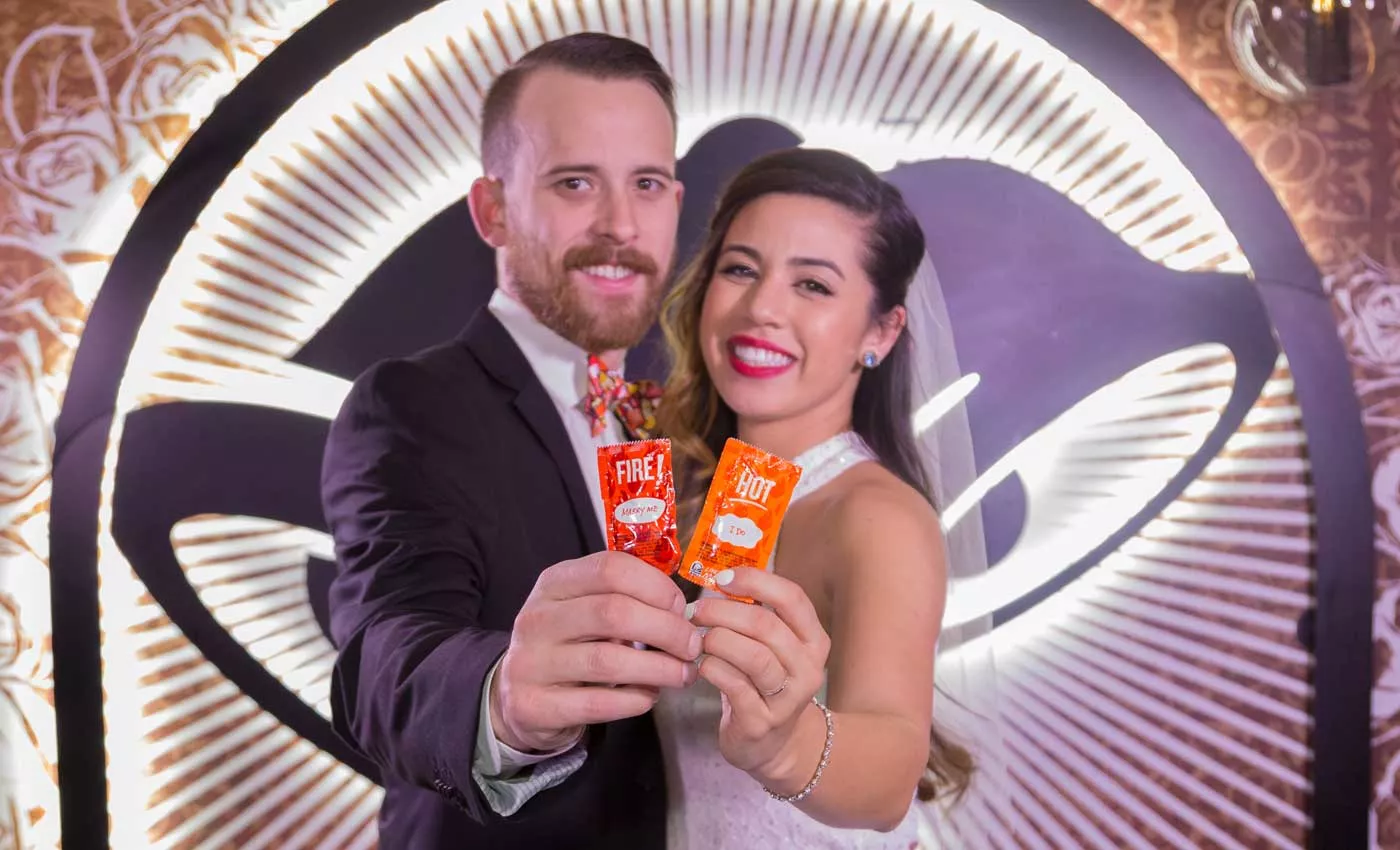 bride and groom show off sauce packets after getting married at the taco bell cantina in las vegas