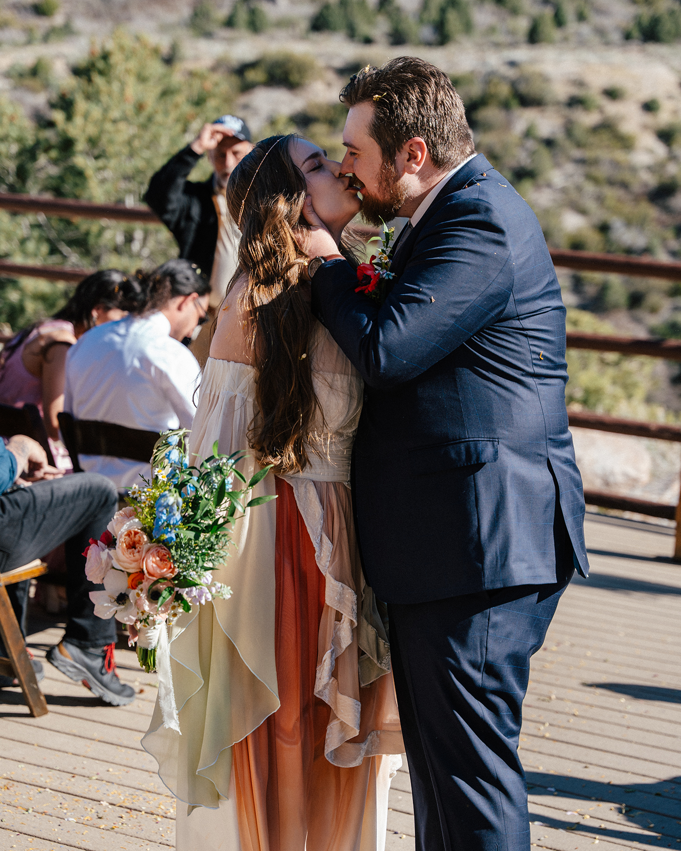 Newly married couple kiss on deck after ceremony at Mt. Charleston Retreat