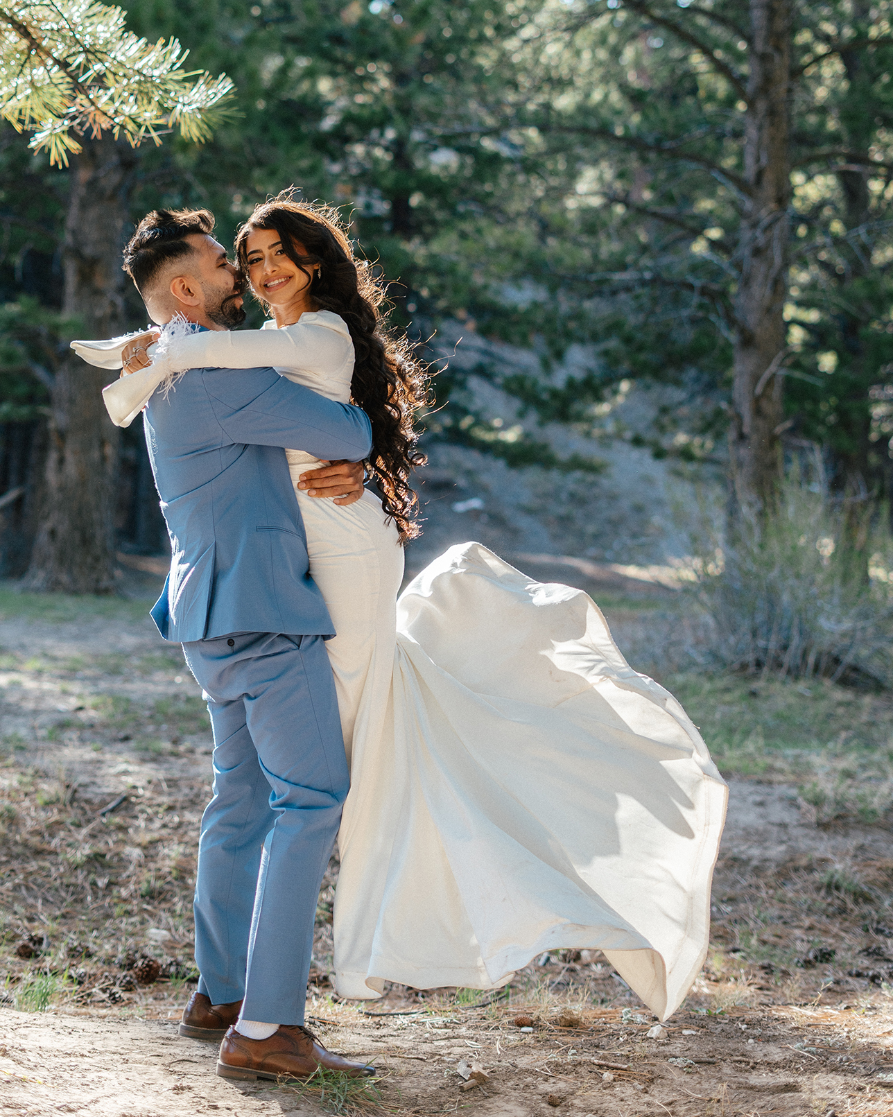 Groom lifts bride in celebration among the pine trees at Lee Canyon.