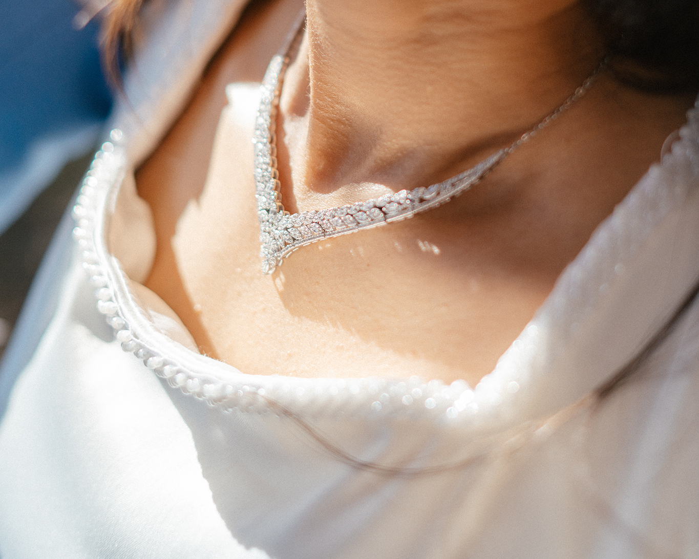 Close-up of diamond necklace and pearl trim on bride’s dress at Lee Canyon.