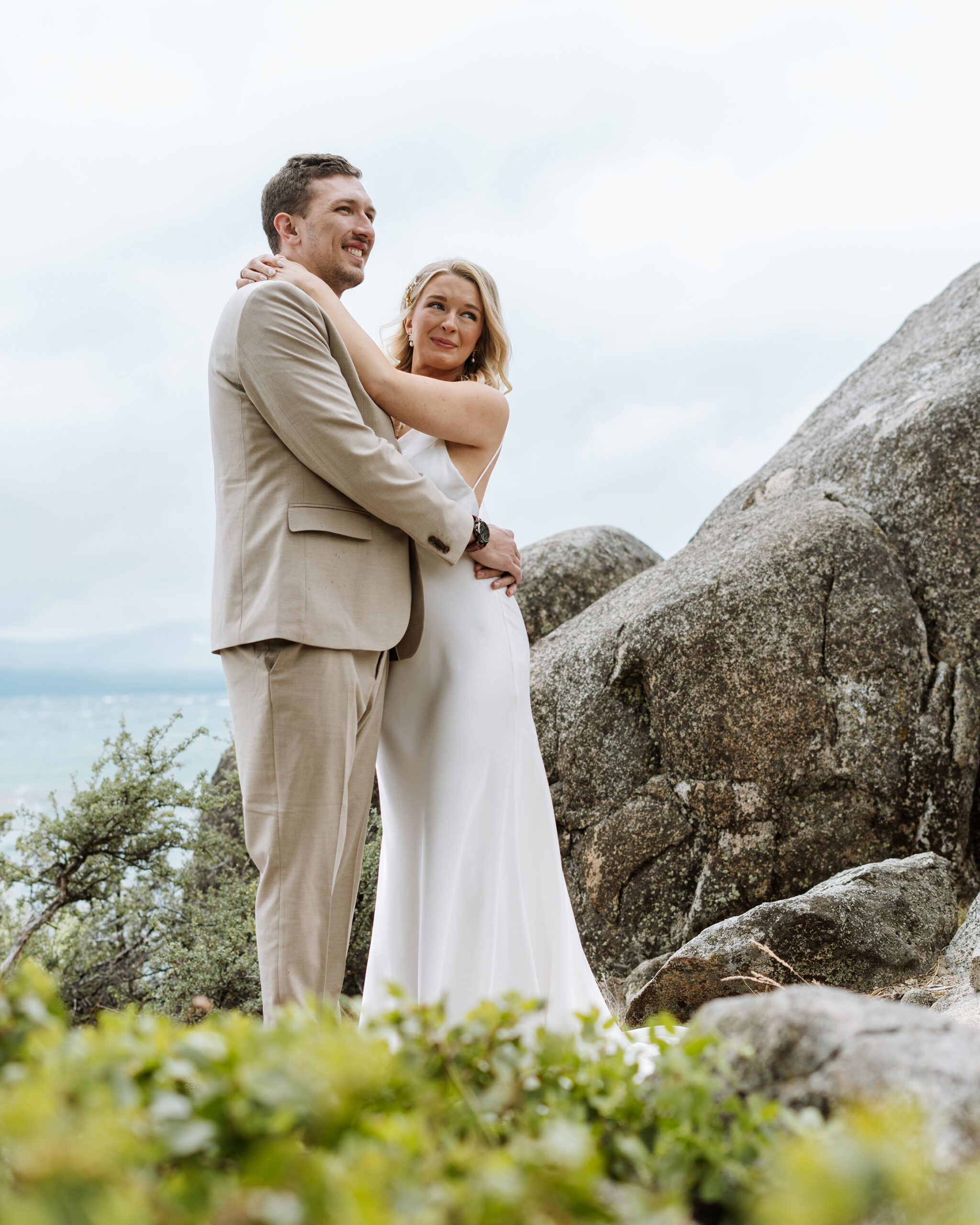 Candid wedding portrait of a couple embracing among granite boulders at their South Lake Tahoe ceremony—natural, romantic, and timelessly elegant.