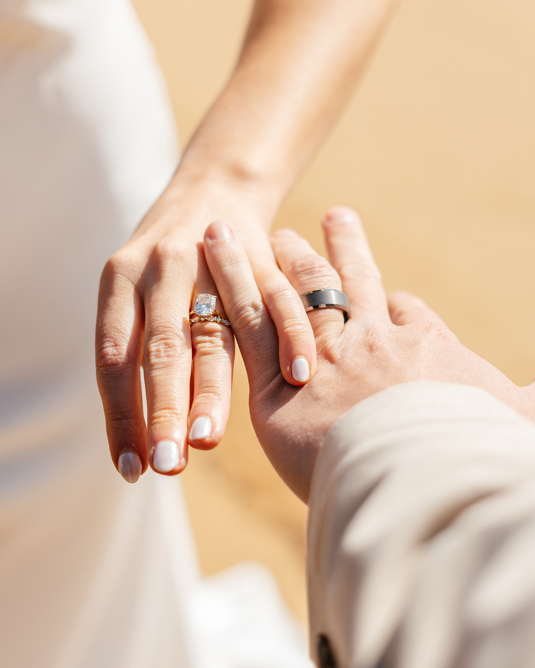 A close-up of the couple’s wedding rings captured on the sand at The Arch at Lakeside Beach in South Lake Tahoe.