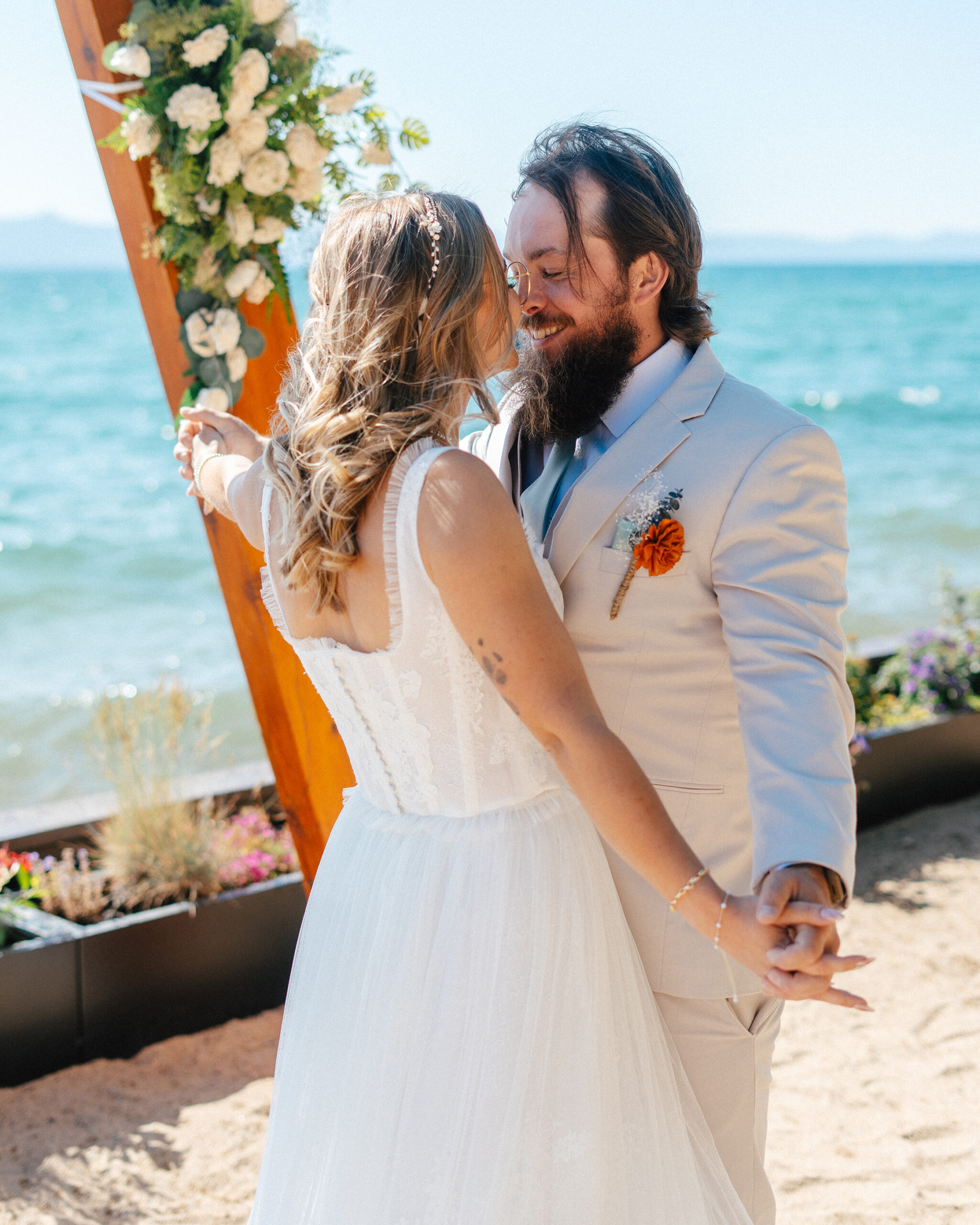 A newlywed couple shares a romantic moment by the lake at their South Lake Tahoe elopement.